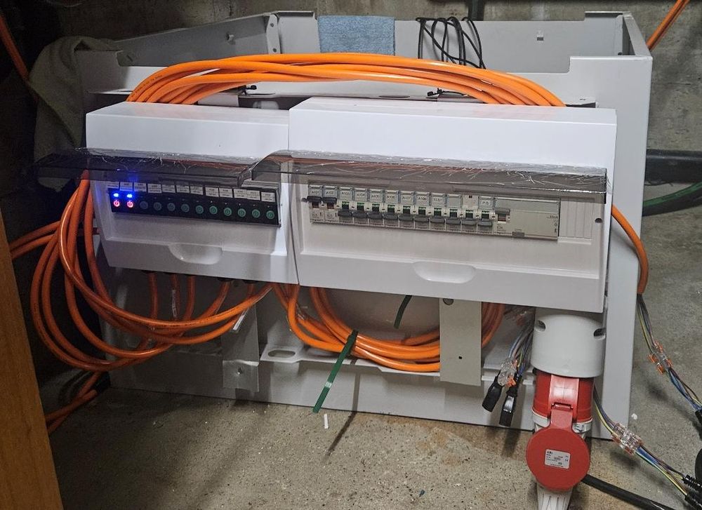 The immersion-cooled compute module, prototype V0.3, with its electrical cabinet and orange power cabling